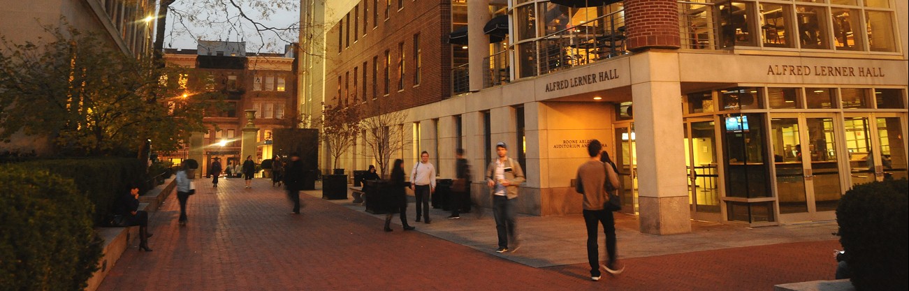 Image of students walking outside Lerner Hall on Columbia campus during twilight. 