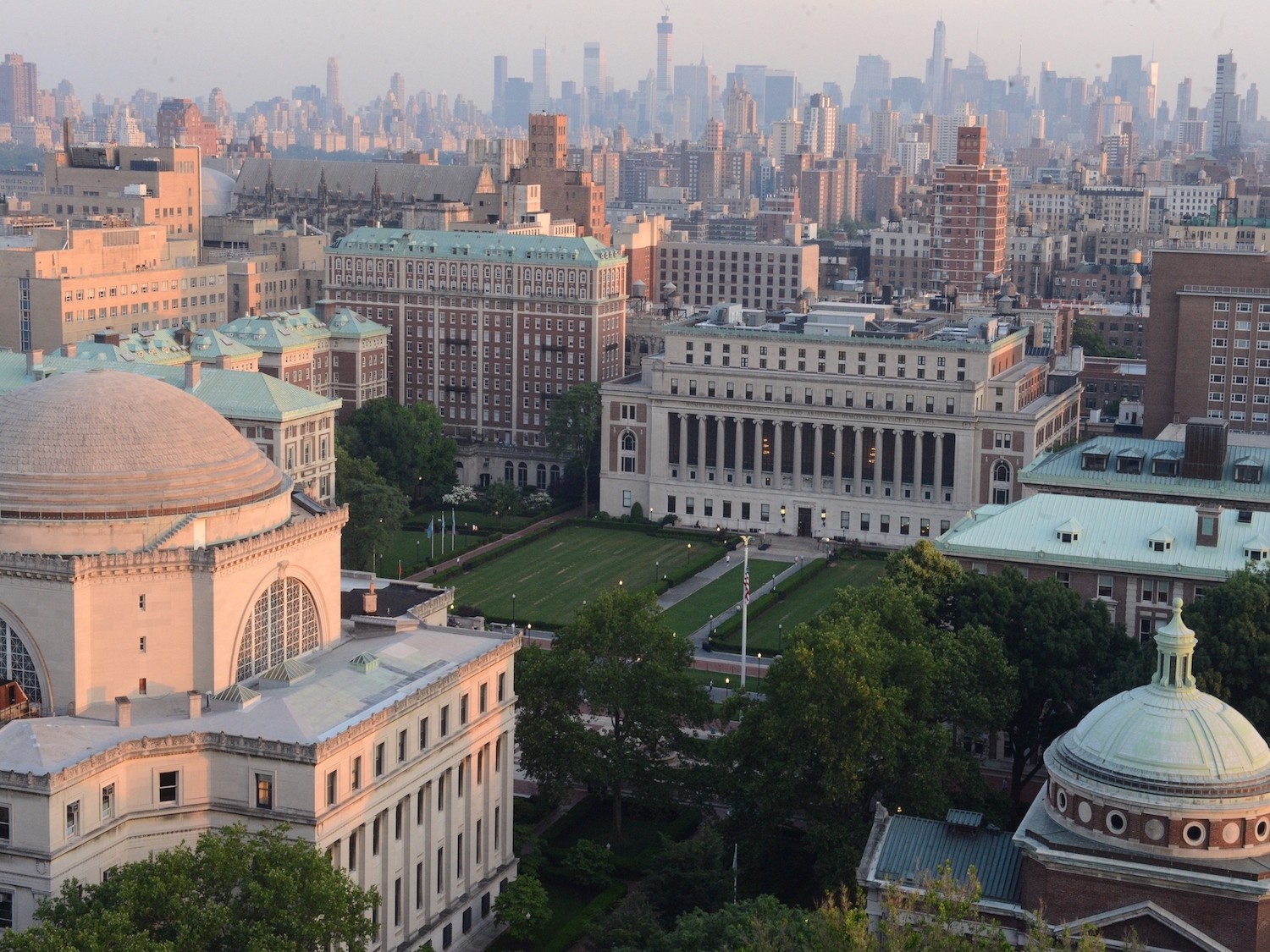 Image of view looking down upon Columbia University campus with NYC skyline in the background.